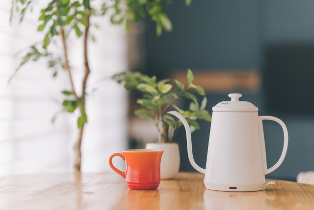 ケトルとコーヒーカップが乗ったテーブルのあるキッチンの写真