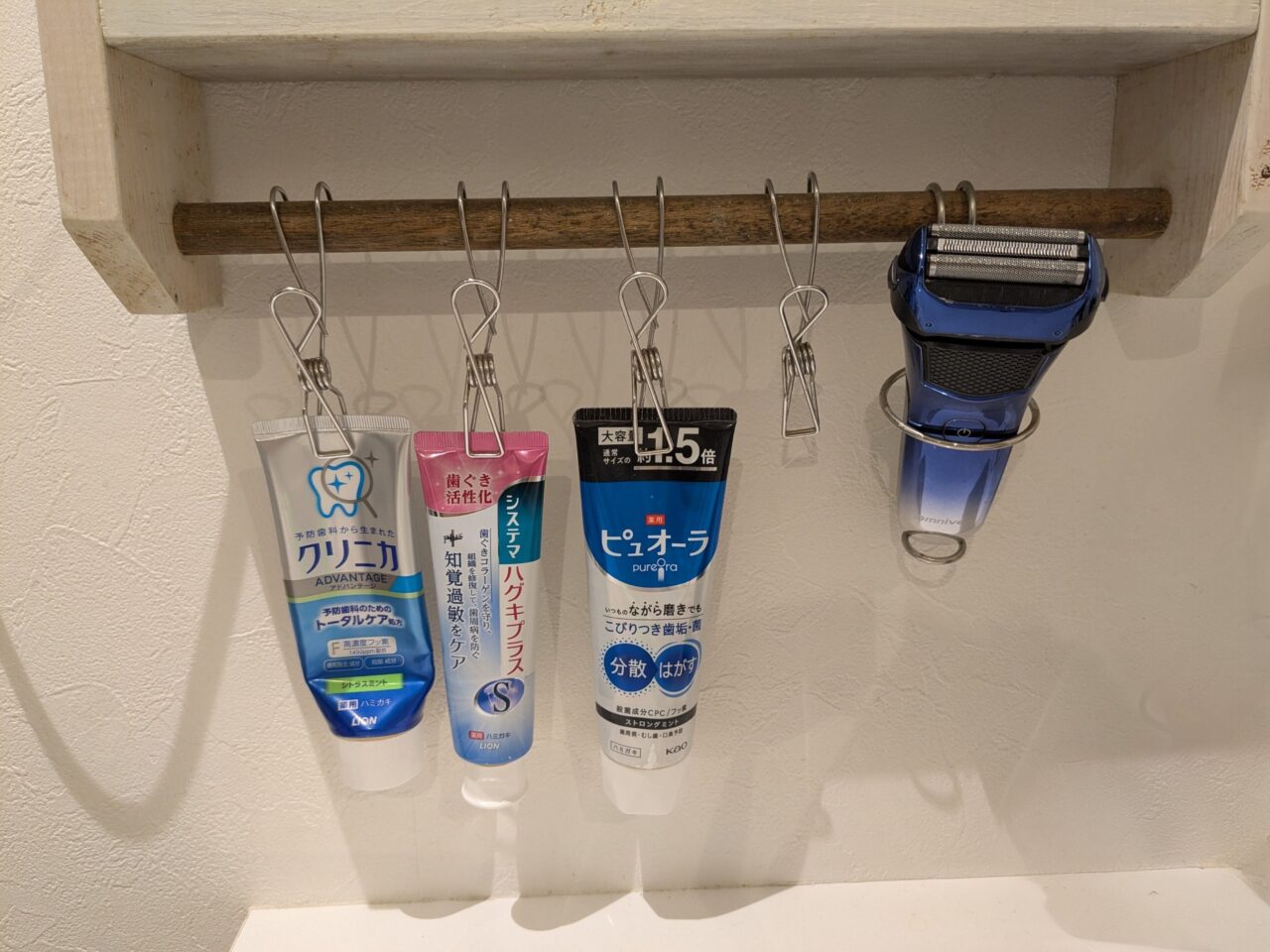 歯磨き粉や髭剃りを吊るして収納している写真。