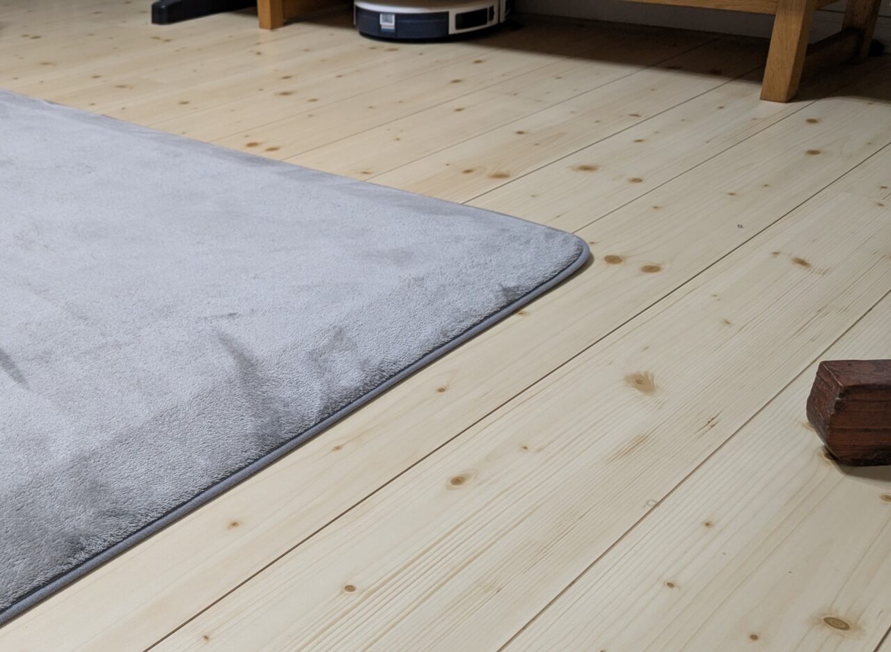 わが家のラグの写真。端にむかって傾斜がついており、足先がひっかかりにくく、お掃除ロボが上りやすい仕様になっているのがわかる写真。