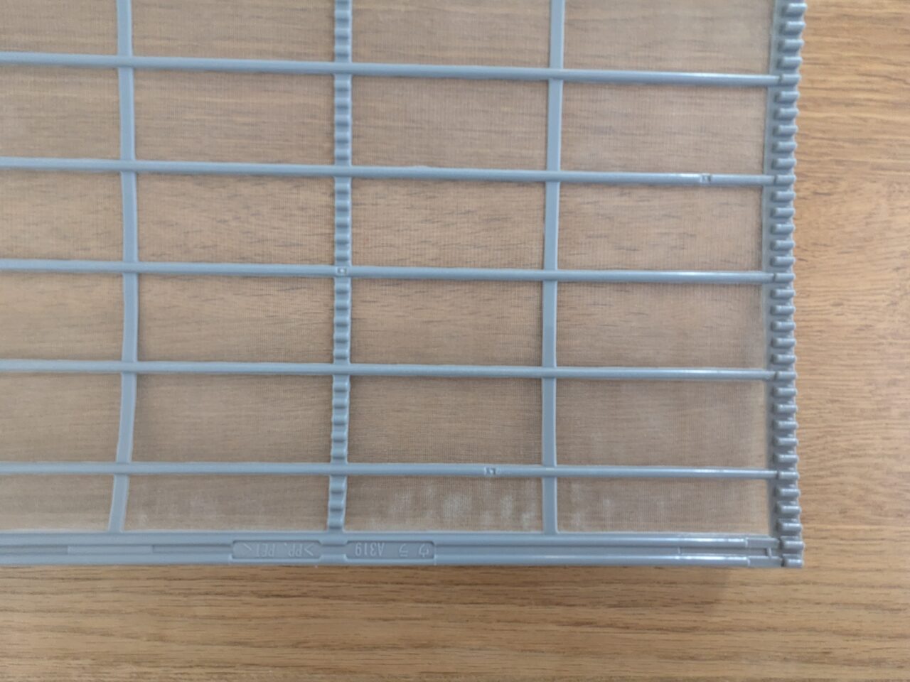 お掃除付きエアコンのフィルターの写真。うっすら汚れあり。